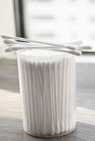 Macro view of white cotton ear cleaning buds arranged in white backgroud nicely in a container photo