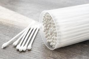 Macro view of white cotton ear cleaning buds arranged in white backgroud nicely in a container photo