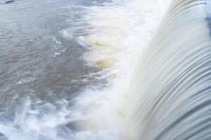 A pure white waterfall background formed in the river througha check dam photo