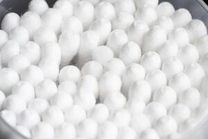 Macro view of white cotton ear cleaning buds arranged in black backgroud nicely in a container photo