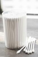 Macro view of white cotton ear cleaning buds arranged in white backgroud nicely in a container photo