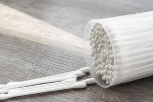 Macro view of white cotton ear cleaning buds arranged in white backgroud nicely in a container photo