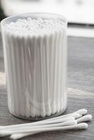 Macro view of white cotton ear cleaning buds arranged in white backgroud nicely in a container photo