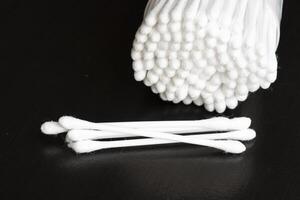 Macro view of white cotton ear cleaning buds arranged in black backgroud nicely in a container photo