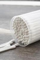 Macro view of white cotton ear cleaning buds arranged in white backgroud nicely in a container photo