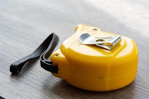 steel metal maesuring tape yelow color macro in a table photo