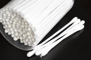 Macro view of white cotton ear cleaning buds arranged in black background nicely in a container photo