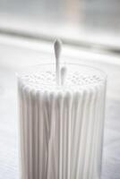 Macro view of white cotton ear cleaning buds arranged in white backgroud nicely in a container photo