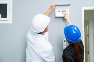 Senior home inspector checking home defects and teaching young engineers, before handing it over to client. Young engineers learn home inspection with Senior, Real estate, and renovation concepts. photo