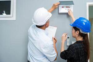 Senior home inspector checking home defects and teaching young engineers, before handing it over to client. Young engineers learn home inspection with Senior, Real estate, and renovation concepts. photo
