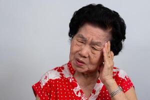 Depressed Asian senior woman lonely disappointed and lose memory in isolated white background. Portrait old woman ill sick depression disease feel sad and unhappy, dementia, health problems concept. photo