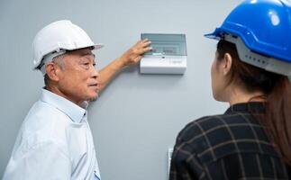 Senior home inspector checking home defects and teaching young engineers, before handing it over to client. Young engineers learn home inspection with Senior, Real estate, and renovation concepts. photo