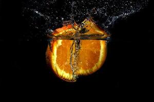 naranja chapoteo dentro agua, desenfocado resumen fondo foto