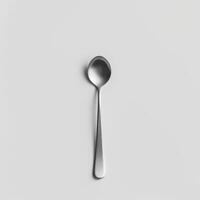 AI generated minimalistic style silver spoon on white background top view photo