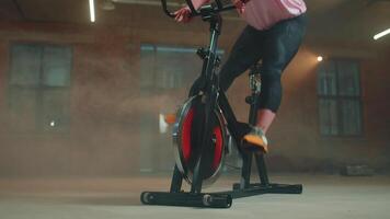 Woman performs aerobic endurance training workout cardio routine on the simulators, cycle training video