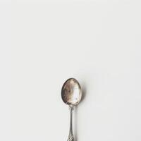 AI generated minimalistic style silver spoon on white background top view photo