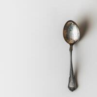 AI generated minimalistic style silver spoon on white background top view photo