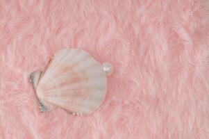 Creative close up composition made with sea shell and white pearl on pastel pink faux fur background. Minimal retro aesthetic romantic concept. Trendy fashion love idea. Luxury layout. Flat lay. photo