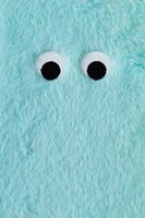 Cute fluffy monster made with light blue faux fur. Minimal concept. Creative funny face composition. An original blue fur cute fluffy monster background image idea. Flat lay, top of view. photo