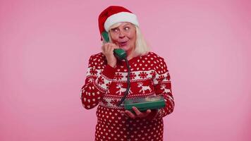 Mature Christmas grandmother woman talking on wired vintage telephone of 80s, hey you call me back video