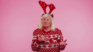 enojado antiguo mujer en Navidad ciervo cornamenta levantamiento manos en indignado expresión disputas conflicto video