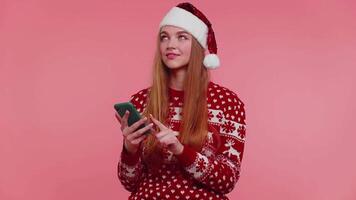 ragazza nel Natale Santa maglione guardare per regali, regalo per amici e famiglia, in linea shopping video