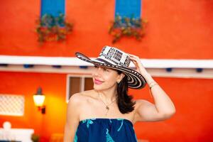 Beautiful woman wearing the traditional Colombian hat called Sombrero Vueltiao at the historical streets of the Cartagena de Indias walled city photo