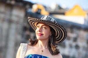 hermosa mujer vistiendo el tradicional Colombiana sombrero llamado sombrero vueltiao a el paz cuadrado en el histórico calles de el cartagena Delaware indios amurallado ciudad foto