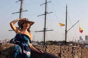 Beautiful woman wearing the traditional Colombian hat called Sombrero Vueltiao at San Ignacio Bulwark in the historical Cartagena de Indias walled city photo