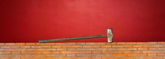 Hammer on red brick wall red cement background photo