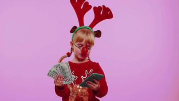 Girl in red Christmas deer antlers looking smartphone rejoicing win success luck receiving money video