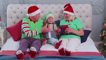 mayor abuelos con nieto niña niño intercambiando regalos a hogar dormitorio cerca Navidad árbol video