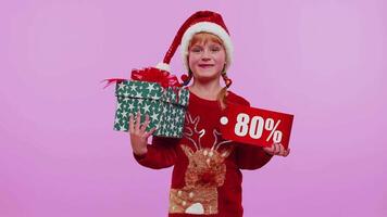 Toddler girl in Christmas hat showing gift box and 80 Percent discount inscriptions banner text note video