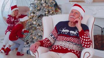 Granddaughter gifting Christmas Xmas present box to amazed happy grandfather at home, celebrating video