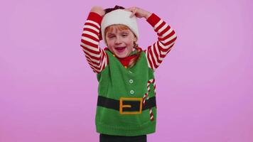 Crazy girl in Santa Christmas costume demonstrating tongue out, fooling around making silly faces video