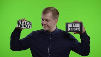 Joyful man showing two Black Friday inscription notes, smiling looking satisfied with low prices video