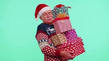 Mature grandfather man in Christmas sweater holding many gift boxes New Year presents shopping sale video