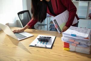 The pile of documents on the secretary's desk was prepared for the executives who would be attending the meeting. Several documents were stacked on the secretary's desk ready for the attendees. photo