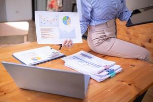 secretary is searching through pile of important documents on office table deliver them to manager for presentation in time at meeting. Concept of difficulty finding information from piles of document photo