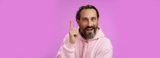 Have great idea listen. Excited energized happy charismatic male bearded guy raising index fingers add suggestion show eureka gesture smiling broadly suggesting perfect plan, purple background photo