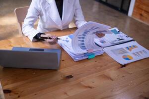 secretary is searching through pile of important documents on office table deliver them to manager for presentation in time at meeting. Concept of difficulty finding information from piles of document photo