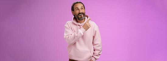 Fascianted joyful handsome mature 40s bearded husband attend interesting amusement park impressed pointing upper left corner enjoying weekend look surprised wondered, gazing alluring product photo