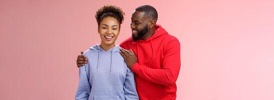 Supportive boyfriend congratulating girlfriend win first prize feel proud touching girl shoulder saying encouraging pleasant words smiling look caring lovely grinning, standing pink background photo