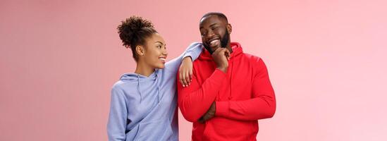 dos mejor amigos teniendo divertido hombre sonriente mujer propensión su hombro hablando riendo bromas me gusta gasto hora juntos, en pie rosado antecedentes charla confidente relajado poses foto