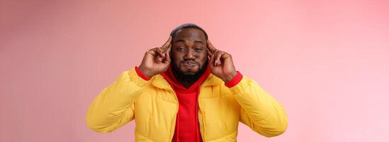 Mind blowing information. Portrait playful charismatic carefree african bearded young 25s man pouting hold breath childish having fun acting immature make funny grimace, standing pink background photo