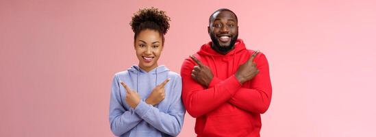 Charming happy couple african american boyfriend girlfriend move in together pointing different sides cross arms chest left right smiling broadly upbeat have variety good choices opportunities photo