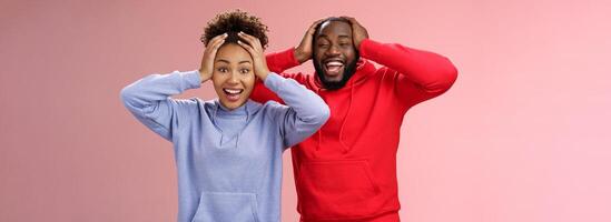 Waist-up happy charming surprised couple african american girlfriend boyfriend winning awesome gift lottery smiling impressed did not except win cannot believe luck grinning holding head shocked photo