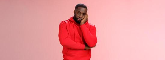 Bored annoyed african-american guy look sceptical dying boredom cannot wait go home lean head palm raise eyebrow judgemental ignorant, standing bothered irritated pink background photo