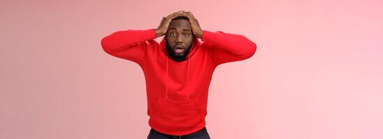 African-american man shocked speechless look upset stupor hold hands head drop jaw gazing dazed cannot believe lost all money, standing upset stunned pink background, receive terrible news photo