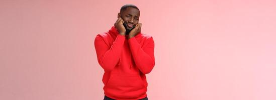 Guy heart melting from cuteness and lovely scene, folding lips silly gay lean head palms look touched impressed gazing beautiful kitten heartwarming scene, standing pink background delighted photo